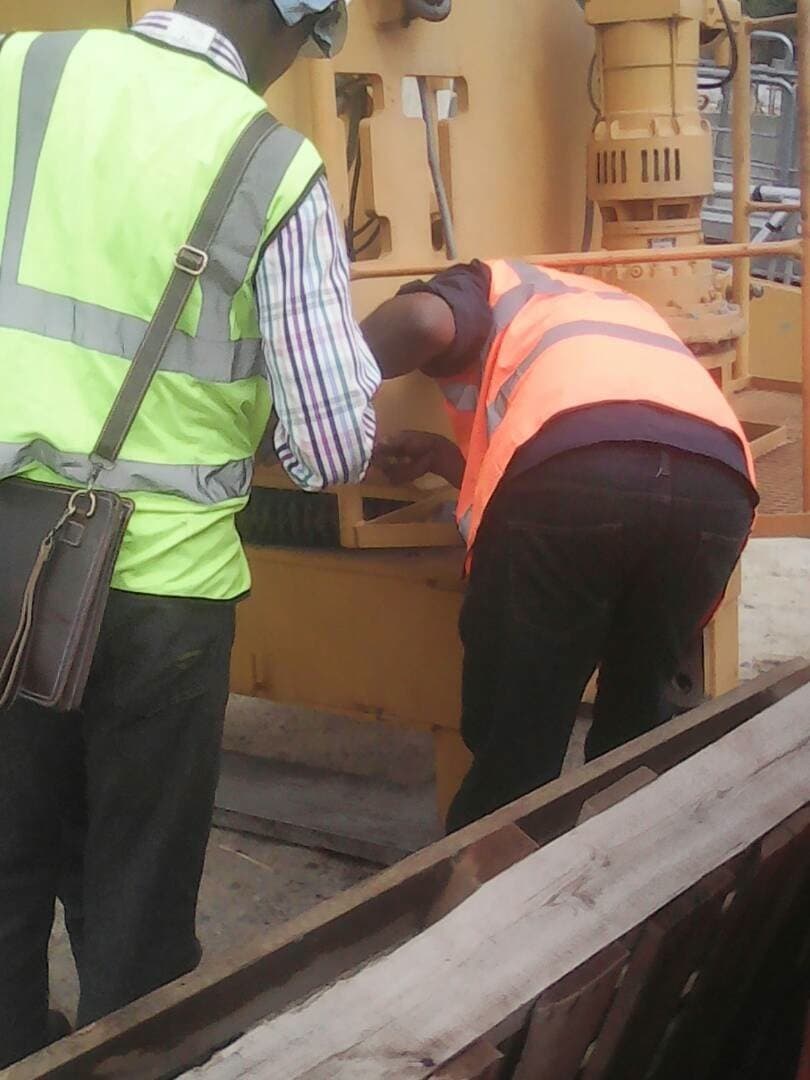 Field engineers in safety vests inspecting industrial equipment on an oil and gas site