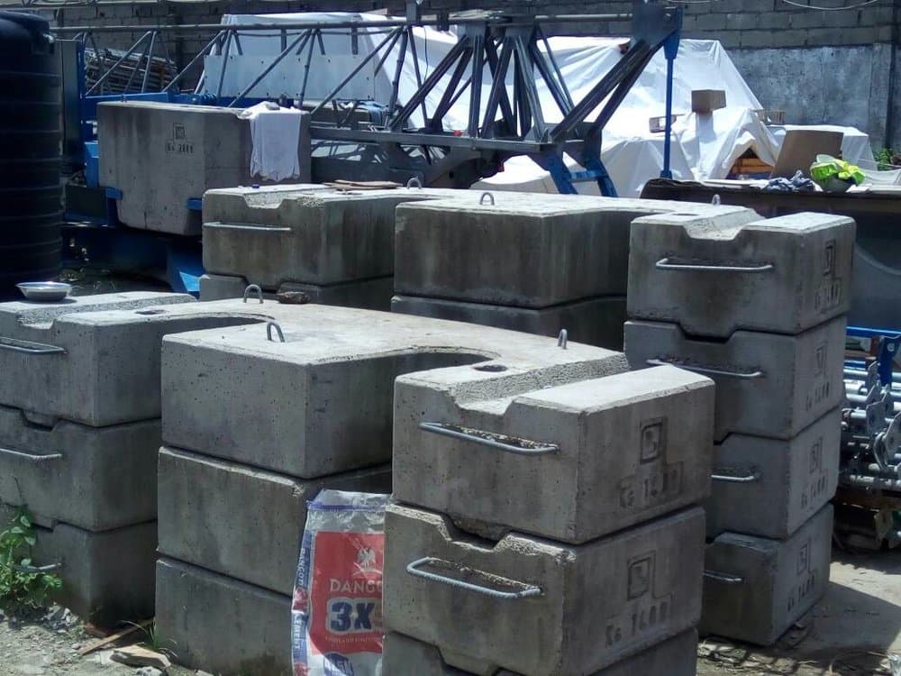 Concrete counterweight blocks stacked at a crane assembly yard